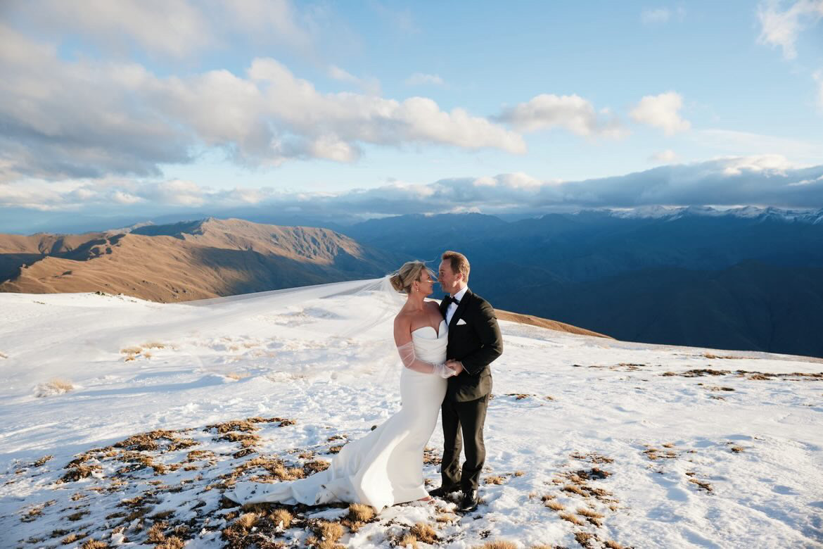 Bride and groom on a snow-covered mountaintop near Queenstown